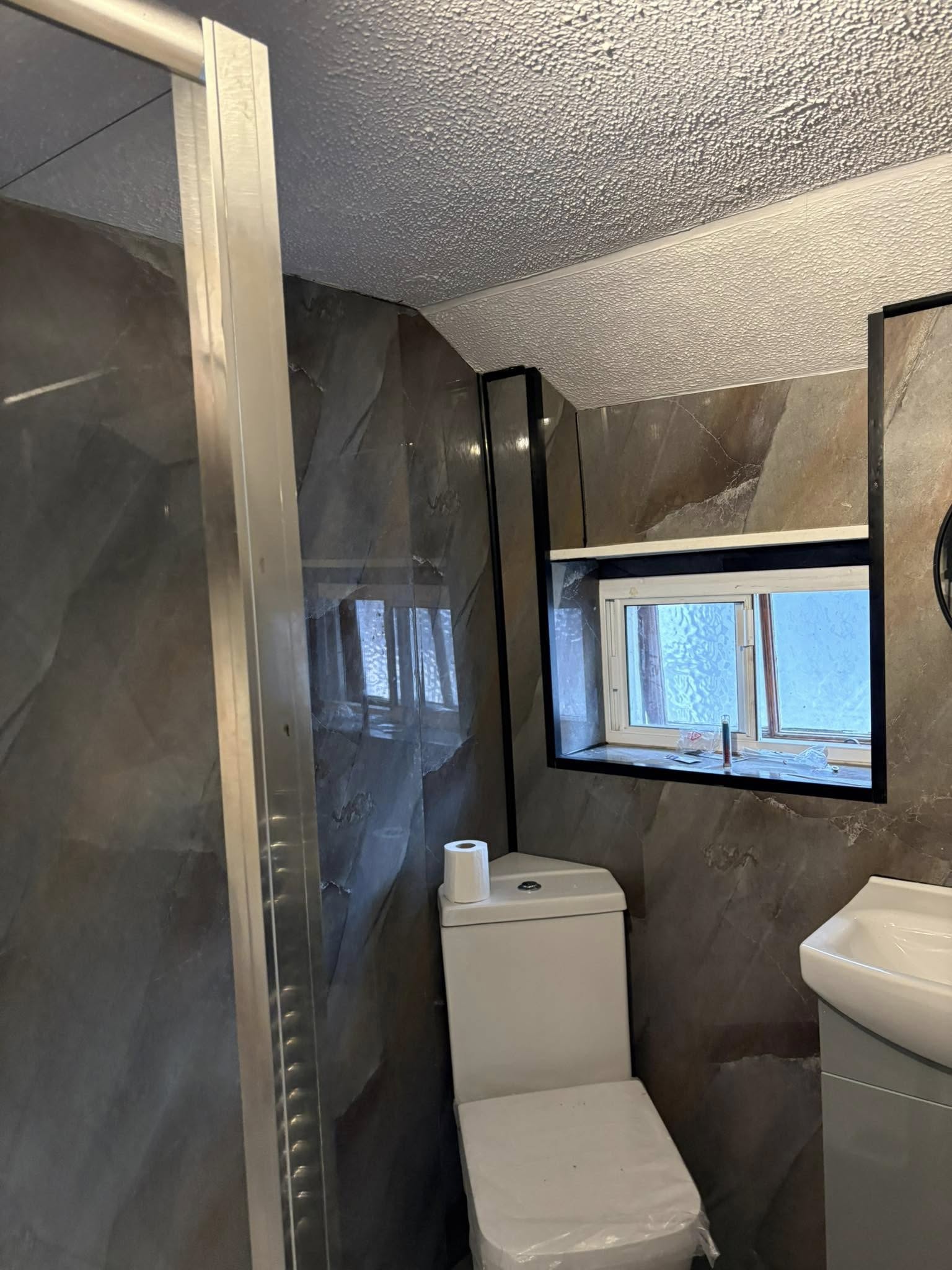 Recently renovated bathroom with new toilet, shower and sink